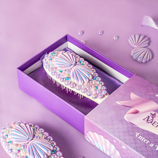 Decorative hairbrush with rhinestones in a purple box on a matching background