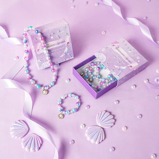 Mermaid-themed jewelry set with necklaces and bracelets on a purple background