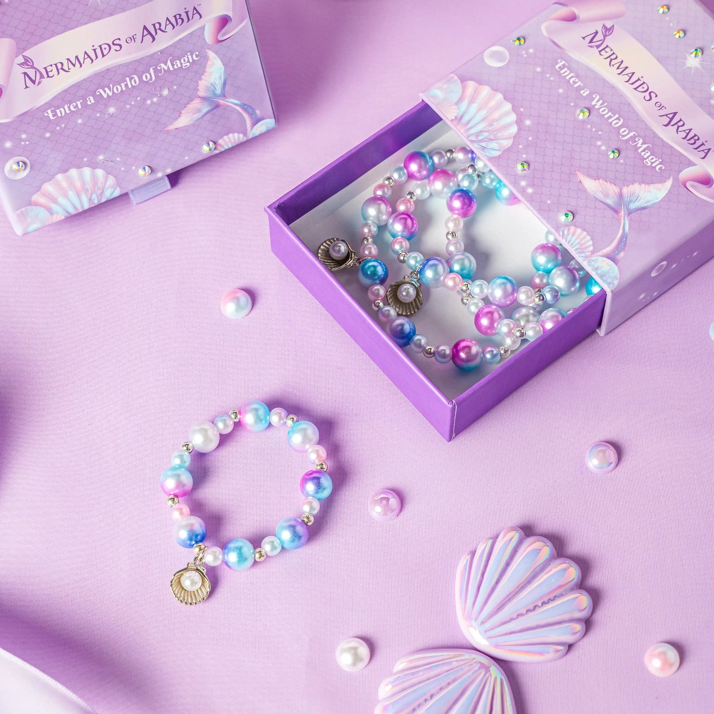 Mermaid-themed jewelry set with bracelets and a box on a purple background