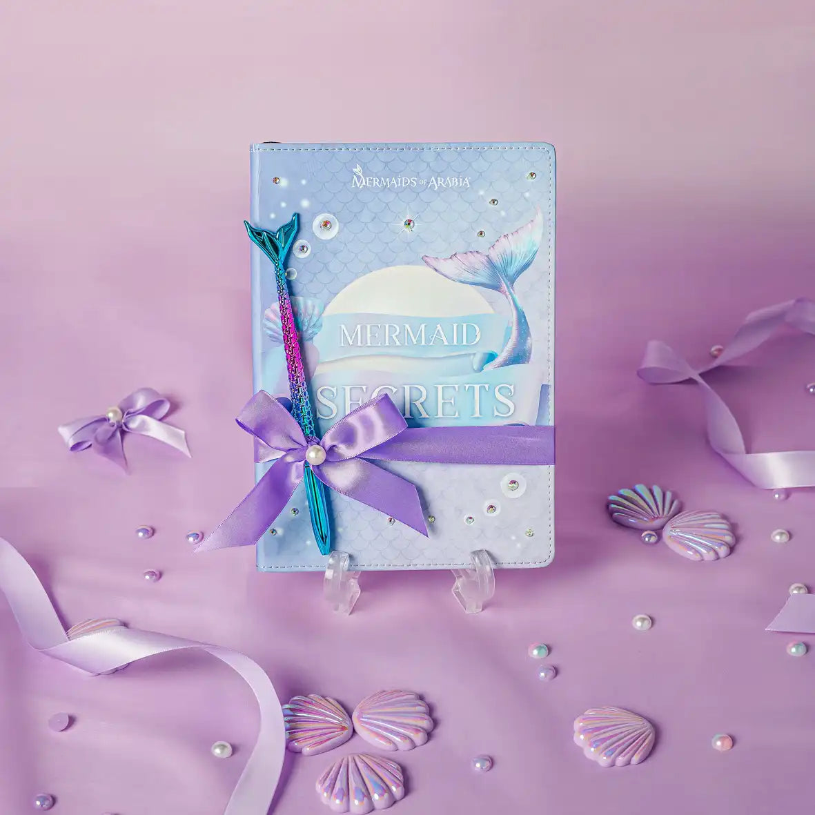 Mermaid-themed notebook with pen on a purple background