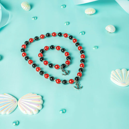 Necklace with black and red beads on a blue background with shells and pearls