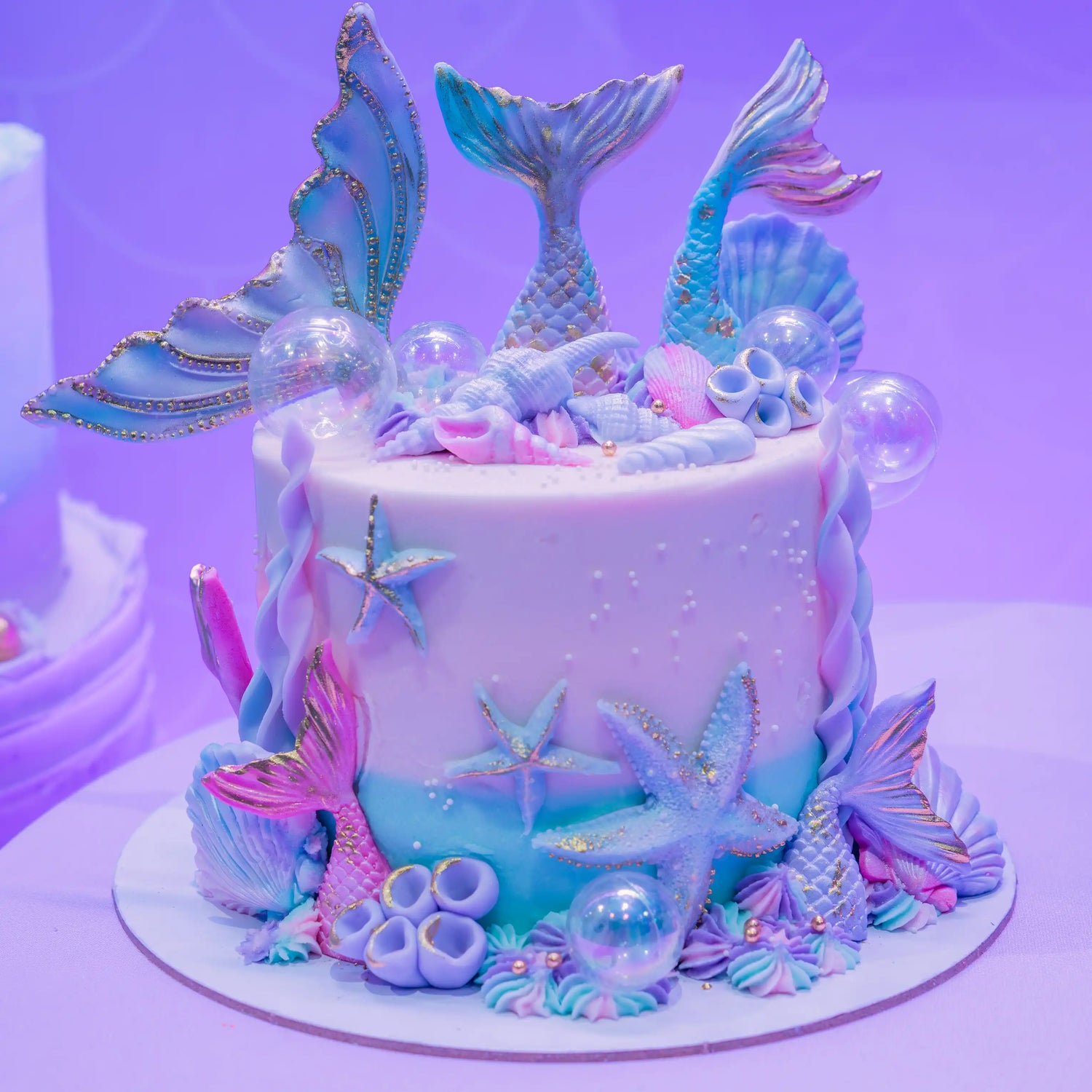 Mermaid-themed cake with decorative elements on a purple background
