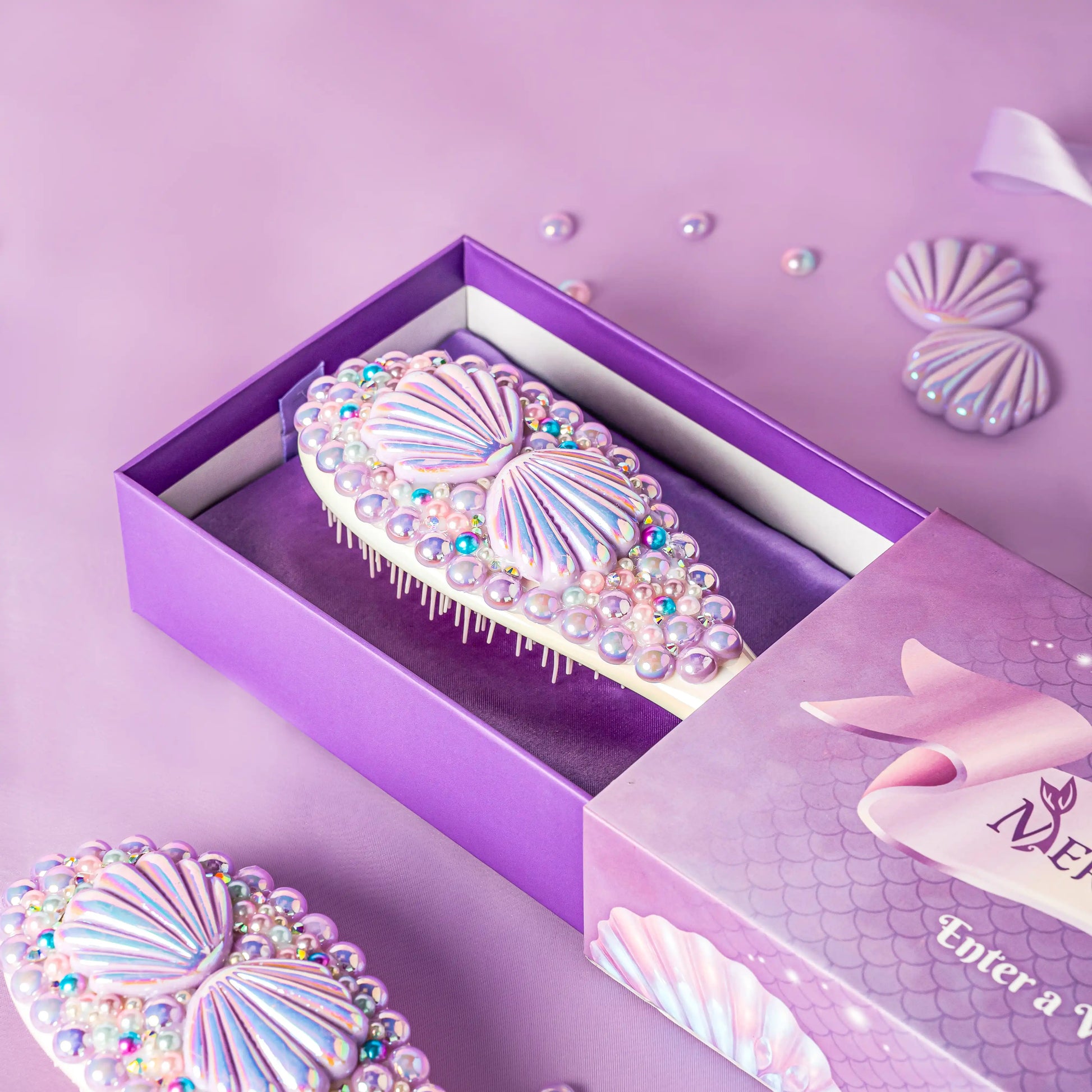 Decorative hairbrush with rhinestones in a purple box on a matching background