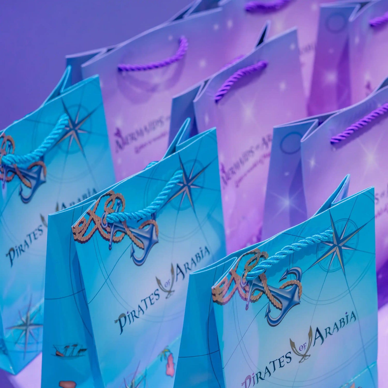 Blue gift bags with 'Pirates of Arabia' design on a purple background