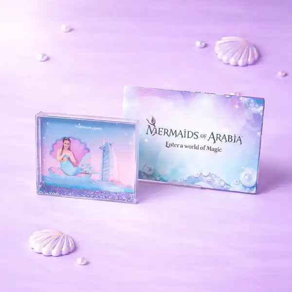 Mermaids of Arabia product packaging on a purple background with seashells.