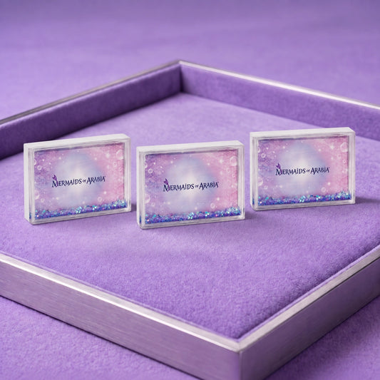 Three rectangular nameplates with a mermaid-themed glitter design and the text 'Mermaids of Arnhic' are displayed in a purple presentation box.