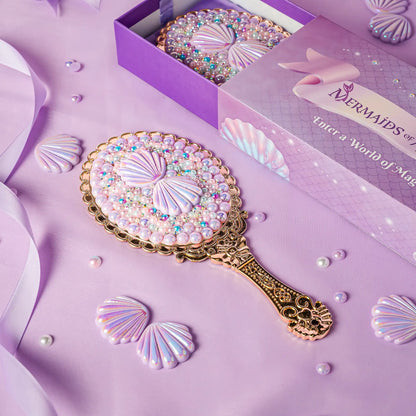 Decorative hand mirror with shell design on a purple background