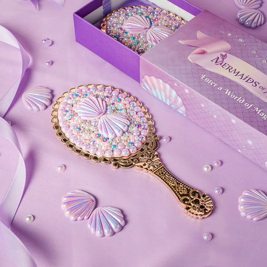 Decorative hand mirror with shell design on a purple background