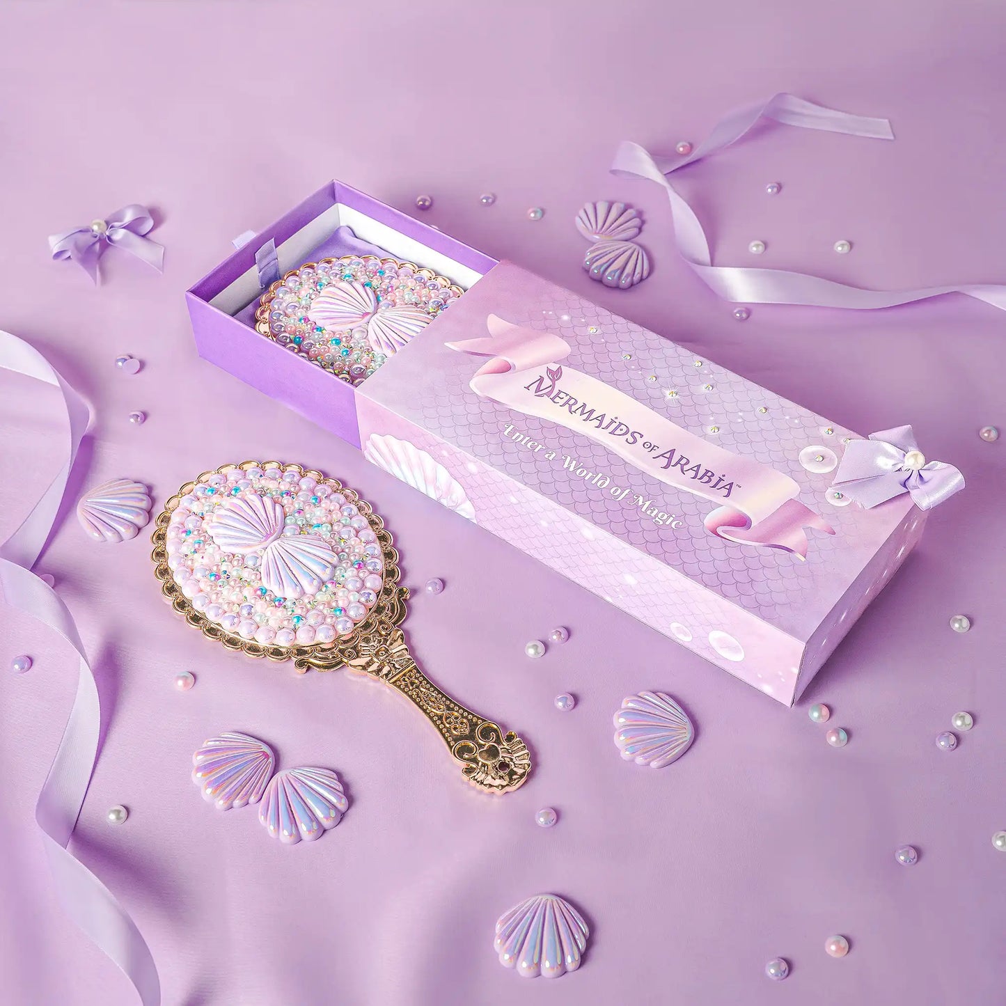 Decorative hand mirror with decorative packaging on a purple background