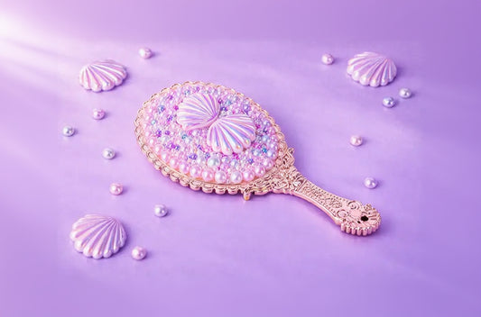 Decorative hand mirror with shell design on a purple background