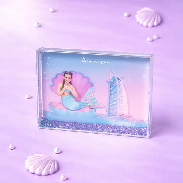 Mermaid figurine in a clear box with a sailboat on a purple background