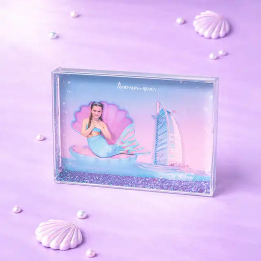Mermaid figurine in a clear box with a sailboat on a purple background