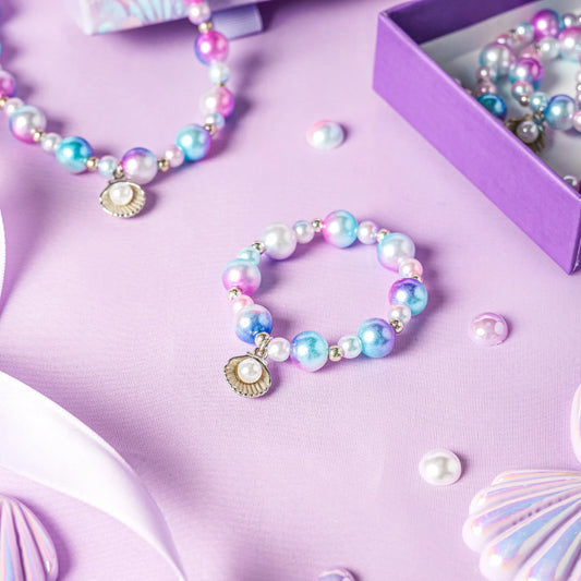 Pastel-colored pearl bracelet with a shell charm on a purple surface
