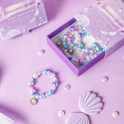 Mermaid-themed jewelry set with bracelets and a box on a purple background