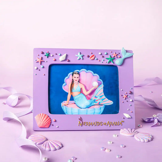 Purple mermaid-themed photo frame with decorative elements on a pink background