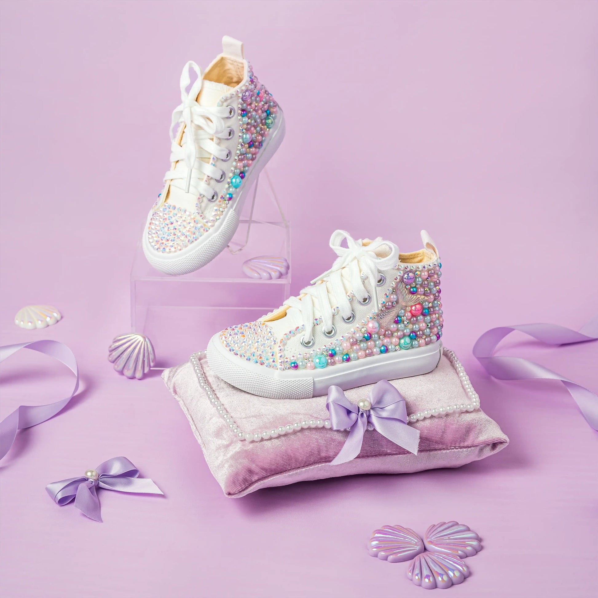 White sneakers with colorful embellishments on a pink background