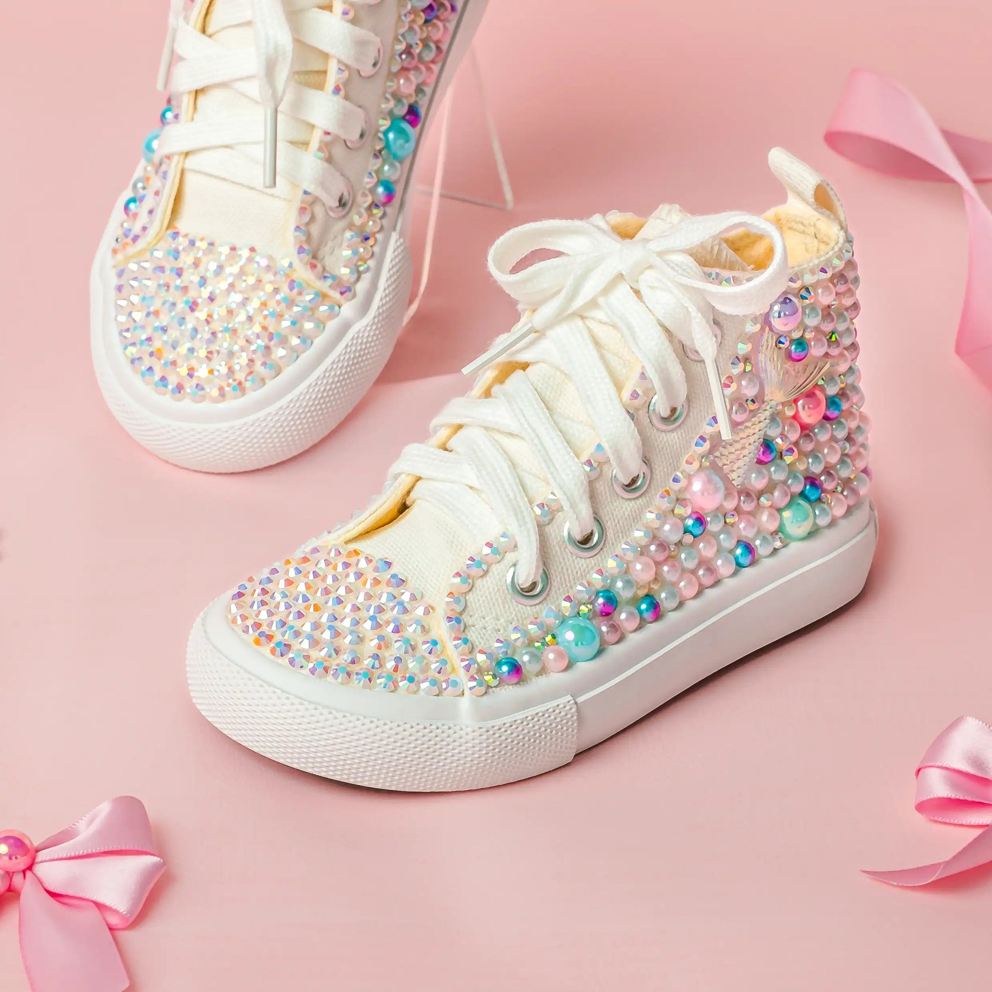 White sneakers with colorful embellishments on a pink background
