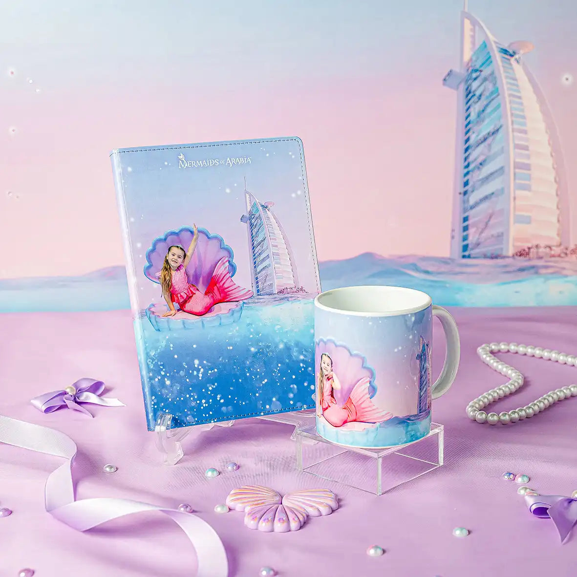 Mermaid-themed mug and notebook with a cityscape background