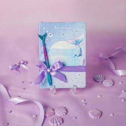 Mermaid-themed notebook with pen on a purple background