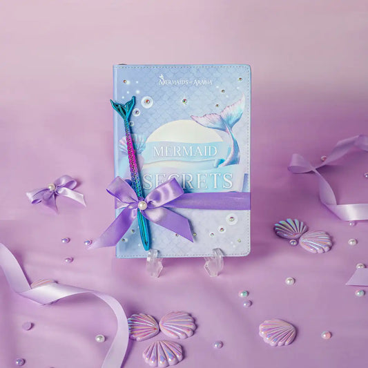 Mermaid-themed notebook with pen on a purple background