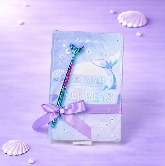 Mermaid-themed notebook with pen on a purple background