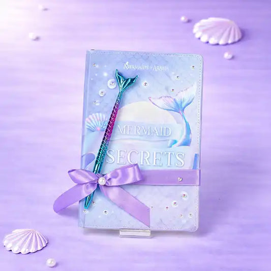 Mermaid-themed notebook with pen on a purple background