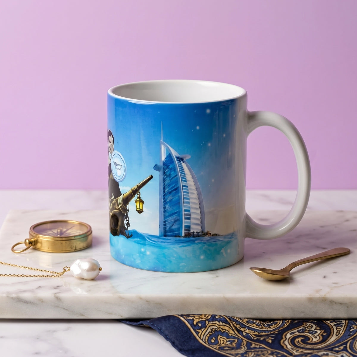 A ceramic mug featuring a printed illustration of a man with a telescope and the Burj Al Arab hotel in Dubai, set on a marble tray with a gold pocket watch, pearl, and spoon against a lavender background.