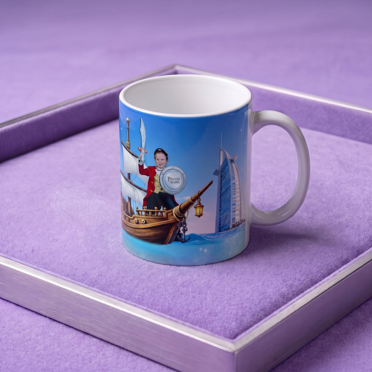 A custom printed ceramic mug with a blue pirate-themed illustration, displayed inside a purple velvet-lined presentation box.