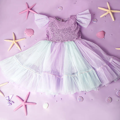 Pastel-colored dress with starfish and shells on a matching purple background