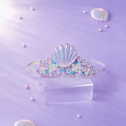 Shell-shaped hair accessory with colorful beads on a purple background