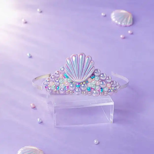 Shell-shaped hair accessory with colorful beads on a purple background