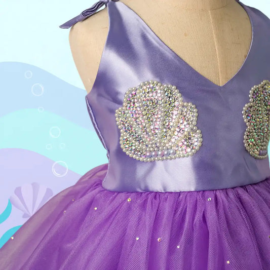 Purple dress with rhinestone embellishments on a mannequin against a colorful background
