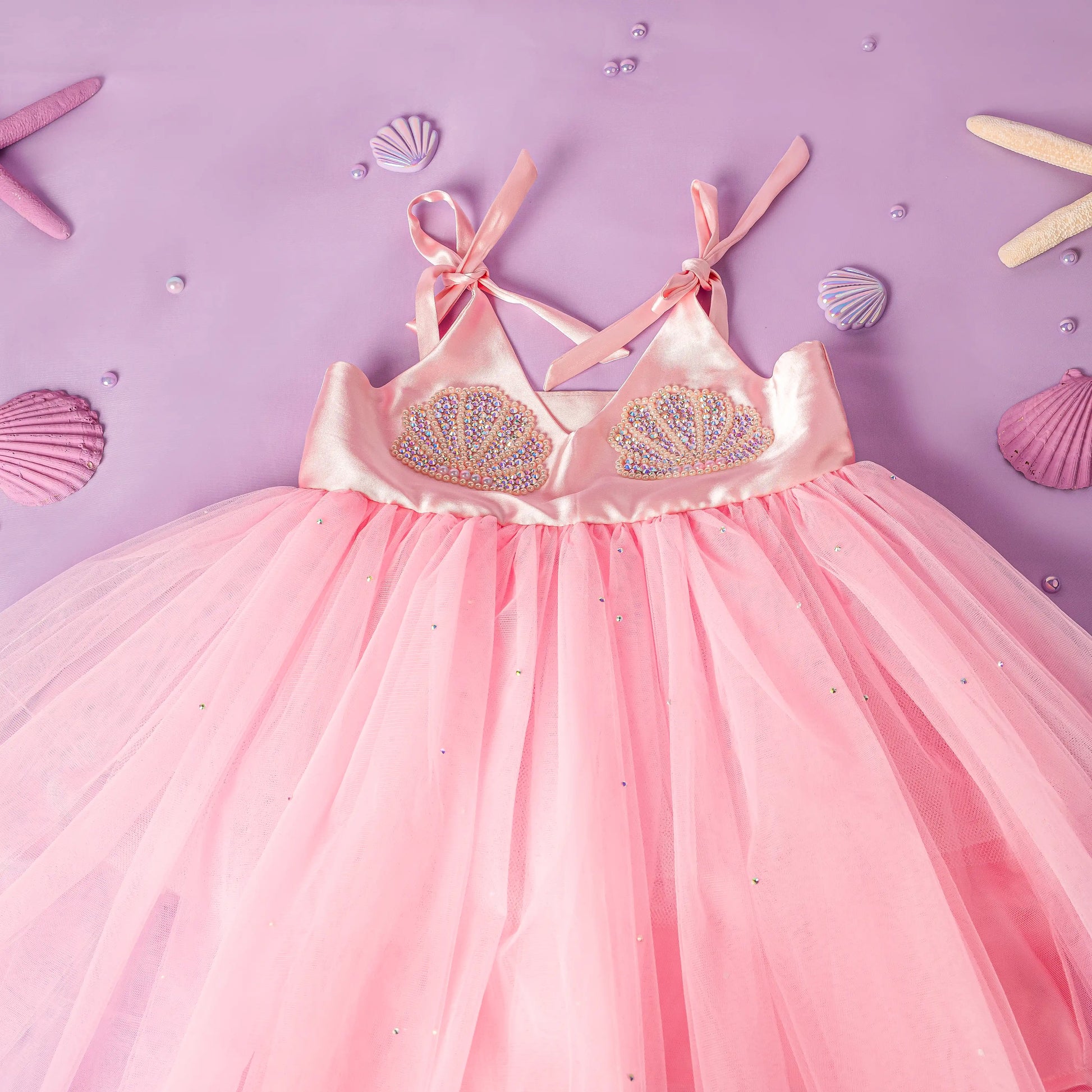 Pink dress with embellishments on a purple background