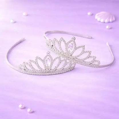 Silver tiara on a light purple background with scattered pearls