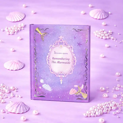 Decorative notebook titled 'Remembering The Mermaids' on a purple background with shells and pearls.