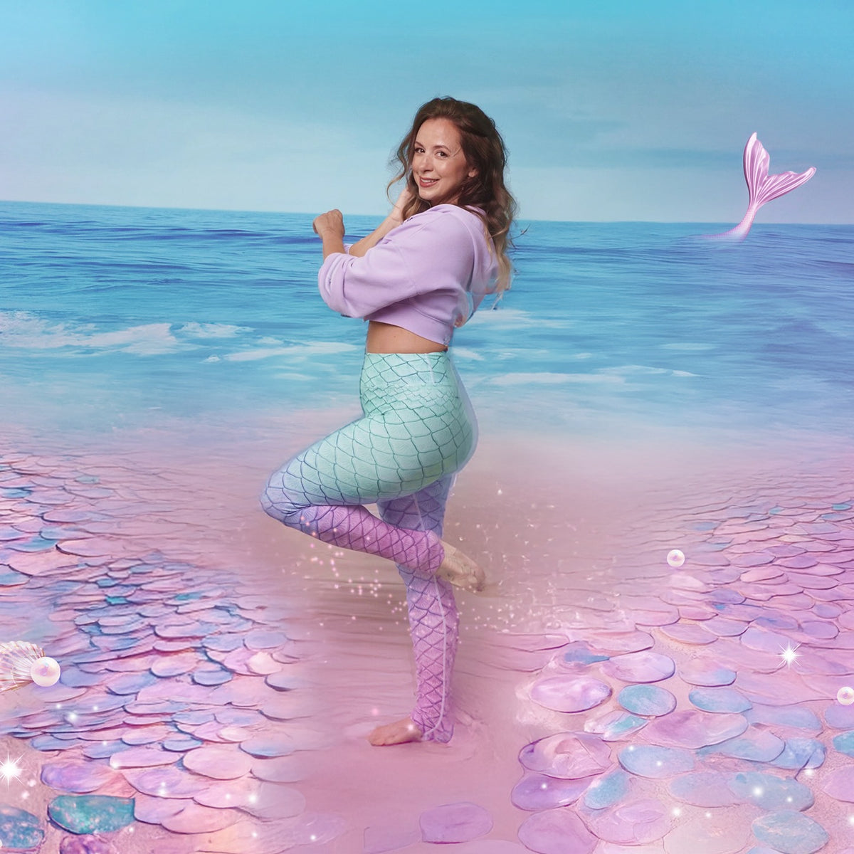 Josephine Adams, founder of Mermaids of Arabia, in a mermaid-scale outfit on a pastel beach